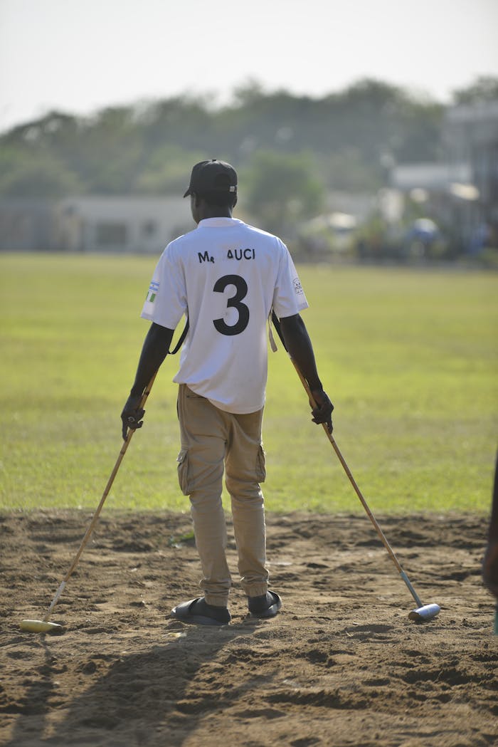 A polo player stands on the field in Abuja, preparing for a match under bright daylight.